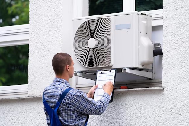 Window-mounted air conditioner undergoing inspection and maintenance